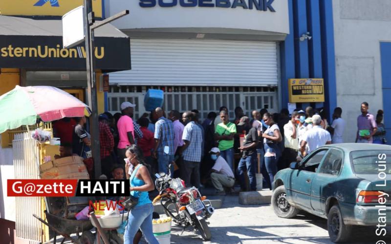 Des cliemts faisant la queue devant la SOGEBANK 