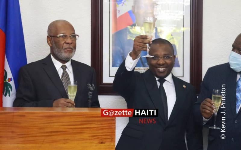Claude Joseph, souriant passe le maillet 